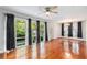 Spacious living room with hardwood floors, a ceiling fan, and large windows overlooking a green yard at 1461 Alverado Way, Decatur, GA 30032