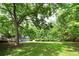 Vast grassy backyard with a house, deck, and storage shed nestled among mature trees at 1810 King Mill Rd, Mcdonough, GA 30252