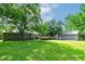 Expansive backyard with a wooden deck attached to a gray house and a detached garage at 1810 King Mill Rd, Mcdonough, GA 30252