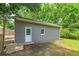 Detached garage with single entry door and a single small window set in a well manicured green backyard at 1810 King Mill Rd, Mcdonough, GA 30252