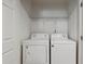 Compact laundry closet with a washer, dryer, and white shelving at 1823 Devon Dr # 1823, Atlanta, GA 30311