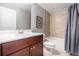 Bathroom featuring wood vanity with white countertop, tile shower, and stylish decorative art at 1946 Jeffery Nw Rd, Atlanta, GA 30318