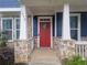 Close-up of a red front door framed by stone columns and blue siding, creating a welcoming entrance at 1946 Jeffery Nw Rd, Atlanta, GA 30318