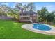 Exterior view of a well-maintained backyard, showcasing a sparkling pool and professionally landscaped lawn at 361 Sarah Ln, Lawrenceville, GA 30046