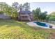 Backyard features pool, landscaped lawn, deck, screened-in porch and a two-story house with a dark roof at 361 Sarah Ln, Lawrenceville, GA 30046