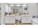 Bright bathroom featuring double sinks, a soaking tub, and a large vanity mirror at 361 Sarah Ln, Lawrenceville, GA 30046