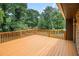 Wide shot of the wood deck overlooking the backyard with lush green trees at 530 Village Green Sw Ct, Lilburn, GA 30047