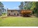 Spacious backyard view showcasing the deck, brick exterior, and a well-maintained lawn for outdoor enjoyment at 530 Village Green Sw Ct, Lilburn, GA 30047