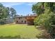 Expansive backyard featuring a spacious lawn, mature trees, and a charming deck area perfect for outdoor enjoyment at 530 Village Green Sw Ct, Lilburn, GA 30047