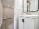 Bathroom with white vanity, black accents and view to gray floored hallway at 530 Village Green Sw Ct, Lilburn, GA 30047