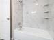 Modern bathroom features a tub with marble-look tile surround and built-in shelving at 530 Village Green Sw Ct, Lilburn, GA 30047