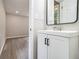 Modern bathroom with white vanity, black hardware, and a view into the adjacent room with wood-look floors at 530 Village Green Sw Ct, Lilburn, GA 30047