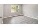 Simple bedroom with wood-look floors, neutral walls, and bright natural light from the large window at 530 Village Green Sw Ct, Lilburn, GA 30047