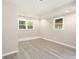 Bright bedroom with two windows and neutral paint, complemented by stylish gray flooring at 530 Village Green Sw Ct, Lilburn, GA 30047