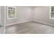 A neutral bedroom features wood-look floors and natural light streaming through large windows at 530 Village Green Sw Ct, Lilburn, GA 30047
