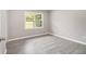Bedroom featuring new gray flooring, baseboard trim, and natural light from large windows at 530 Village Green Sw Ct, Lilburn, GA 30047