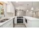 A bright, modern kitchen featuring stainless steel appliances, a white island, and gray vinyl floors at 530 Village Green Sw Ct, Lilburn, GA 30047