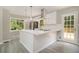 A modern kitchen with stainless steel appliances, a large island, and lots of natural light at 530 Village Green Sw Ct, Lilburn, GA 30047