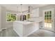 Contemporary kitchen featuring a large island, stainless steel appliances, and deck access at 530 Village Green Sw Ct, Lilburn, GA 30047