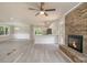 Bright and airy living room featuring modern kitchen, brick fireplace, and wood-look floors at 530 Village Green Sw Ct, Lilburn, GA 30047