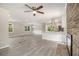 Open living space features gray flooring, ceiling fan, fireplace, and modern kitchen at 530 Village Green Sw Ct, Lilburn, GA 30047