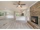 Open living space features gray flooring, brick fireplace, and modern kitchen at 530 Village Green Sw Ct, Lilburn, GA 30047