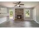 Living room with brick fireplace, backyard access, and modern gray flooring at 530 Village Green Sw Ct, Lilburn, GA 30047