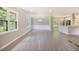 Spacious living room featuring modern gray vinyl floors, neutral paint, and large windows providing ample natural light at 530 Village Green Sw Ct, Lilburn, GA 30047