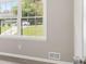 Sunlight streams into this room with wood-look flooring through the bright window. Car and trash bins visible at 530 Village Green Sw Ct, Lilburn, GA 30047