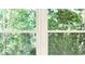 Exterior view of a wooded backyard as seen through a bright window at 530 Village Green Sw Ct, Lilburn, GA 30047