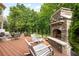 Inviting outdoor deck with stone fireplace and comfortable seating area overlooks wooded backyard at 1235 Grand View Se Dr, Smyrna, GA 30126