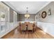 Formal dining room with hardwood floors, neutral walls, wainscoting, and a modern chandelier at 1235 Grand View Se Dr, Smyrna, GA 30126