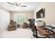Bright office space with a large window with shutters and a dark wood desk illuminated by a modern ceiling fan at 1235 Grand View Se Dr, Smyrna, GA 30126