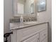 Bathroom vanity features granite counters, a white cabinet, and stylish framed mirrors at 2015 Wingate Way, Atlanta, GA 30350