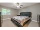 Bedroom featuring a tufted headboard, ceiling fan, and large window at 2015 Wingate Way, Atlanta, GA 30350