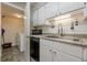 This kitchen features white cabinets and stainless steel appliances with laundry room access at 2015 Wingate Way, Atlanta, GA 30350