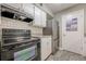 This kitchen features white cabinets, stainless steel refrigerator and black oven at 2015 Wingate Way, Atlanta, GA 30350