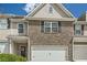 Charming two-story townhome with brick facade, gray siding, and a two-car garage at 3070 Fareed St, Douglasville, GA 30135