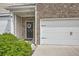 Close-up of the townhome's front door and two-car garage, with a wreath on the door at 3070 Fareed St, Douglasville, GA 30135