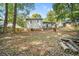 Wide shot of backyard with mature trees, a patio, and ample space for outdoor recreation and relaxation at 3227 Fescue Cir, Lawrenceville, GA 30044