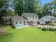 View of well-maintained two-story home, showcasing a lush lawn and mature trees enhancing the property's curb appeal at 3227 Fescue Cir, Lawrenceville, GA 30044