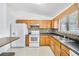 Bright kitchen featuring wood cabinets, tile backsplash, and white appliances, perfect for cooking at 3227 Fescue Cir, Lawrenceville, GA 30044