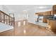 Bright living room featuring hardwood floors, a staircase, and an open layout to the kitchen at 3227 Fescue Cir, Lawrenceville, GA 30044