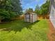 Fenced backyard with storage shed and lush green lawn at 6795 Browns Mill Walk, Lithonia, GA 30038