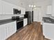 Clean kitchen with stainless steel appliances, white cabinets, and hardwood floors at 6795 Browns Mill Walk, Lithonia, GA 30038