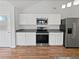 Clean kitchen with stainless steel appliances, white cabinets, and hardwood floors at 6795 Browns Mill Walk, Lithonia, GA 30038