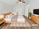 Staged main bedroom featuring hardwood floors, ceiling fan, and ensuite access at 6795 Browns Mill Walk, Lithonia, GA 30038