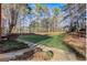Large backyard with a well-maintained lawn, mature trees, and an adjacent patio at 1090 Crown River Pkwy, Mcdonough, GA 30252