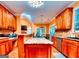 Spacious kitchen with wood cabinets, granite counters, a gas cooktop island, and stainless appliances at 1090 Crown River Pkwy, Mcdonough, GA 30252
