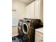 Functional laundry room with modern washer and dryer, and white cabinets at 1090 Crown River Pkwy, Mcdonough, GA 30252